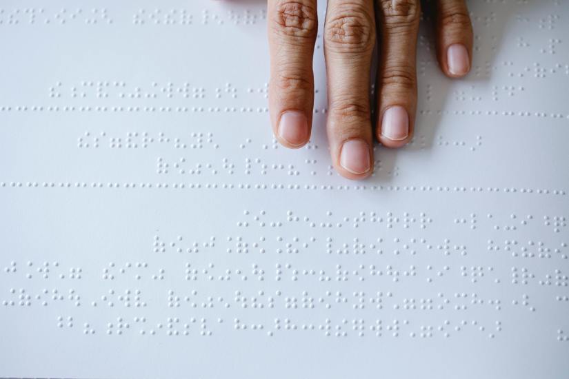 Eine Hand, die gerade Braille liest.